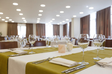 Empty glass goblets and cutlery on green napkin on table