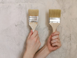 A set of brushes for painting in the hand. Beige background. Repair in the apartment.