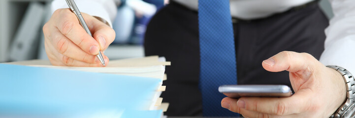 Businessman signs stack documents in table office