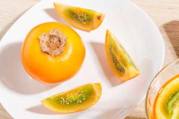 glass with juice and slices of lulo fruit, on the table