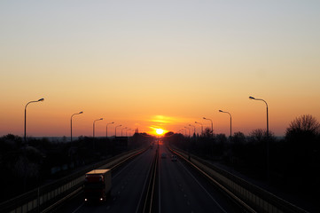 Fototapeta na wymiar dawn and sunset on the road, transport at dawn, cars go to sunset
