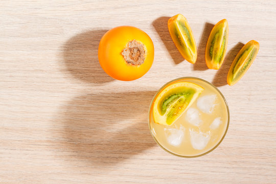 glass with juice and slices of lulo fruit, on the table