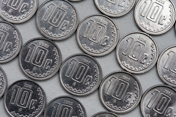 Monedas de 10 centavos acomodadas en linea sobre un fondo de color gris