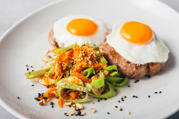 baked eggs and burgers meal with roasted vegetables
