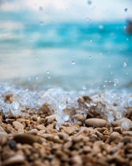 A close shot of pebbles that the sea wave rises