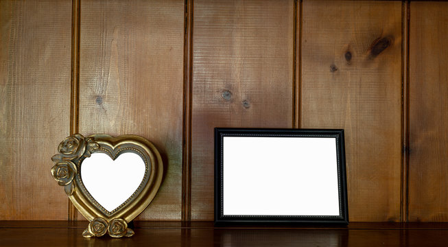 Mock up of blank  black & heart shaped  picture frame on wooden counter  against wood  background.