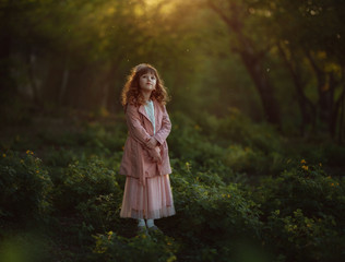 
beautiful girl with curly hair watches luminous flies in a mysterious forest in the spring hacky sun