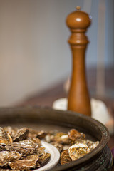 Healthy sea food, fresh Oysters with pepper gourmet close-up on white and black plate served in a restaurant