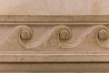 Part of a decorative ornament on a fragment of a marble structural element of an old building in Rome, Italy