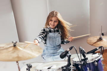 Fototapeta na wymiar teenage girl playing drums in studio