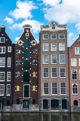 Fototapeta premium Old traditional leaning houses along the canal in Amsterdam, Netherlands