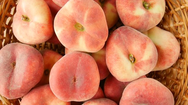 Flat peaches in the basket.