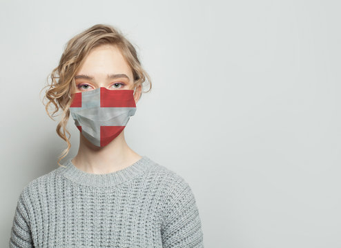 Young woman wearing a face mask with national flag Denmark. Flu epidemic and virus protection concept
