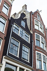 Fototapeta premium Old traditional leaning houses in Amsterdam, Netherlands