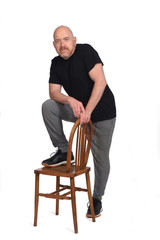 man standing with a chair in white background