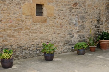 Fototapeta na wymiar Pots next to stone wall