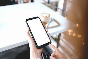 Close up of woman using cell phone sending massages  for shopping online within the cafe.having sunbath.Phone with black screen,texting,video calls.