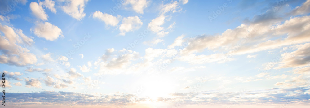 Wall mural blue sky clouds background. beautiful landscape with clouds and orange sun on sky