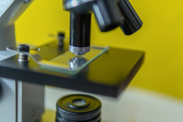 Fototapeta na wymiar Microscope on a jelly background, approaching with illumination and three lenses, training