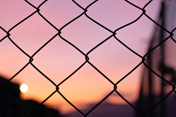 Purple sunset behind a fence.