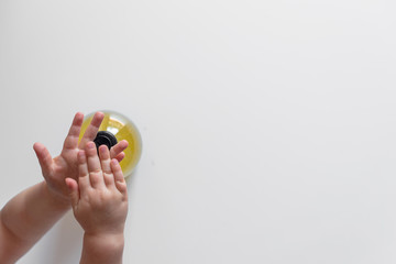 Fototapeta na wymiar baby child washing hands with antibacterial liquid soap dispenser. Coronavirus (Covid-19) preventive measures top view concept - top view - flat lay - banner