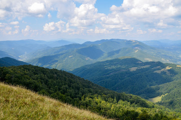 Panoramic view of picturesque Carpathian Mountains landscape with forest slopes, mountain ranges and peaks. Holidays in the mountains.