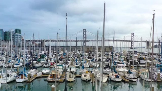 aerial shot of yachts in San Francisco bay near the Oakland Bay bridge in dark moody weather conditions