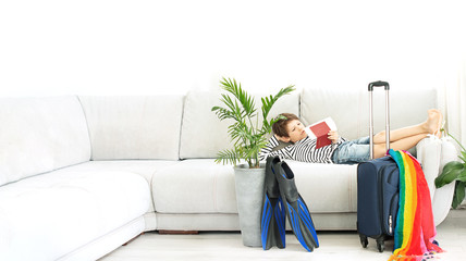 Tourist boy with a suitcase and flippers stays at home during the coronavirus pandemic. Cancellation of leave and closing of borders between countries. Flight cancellation © Irina