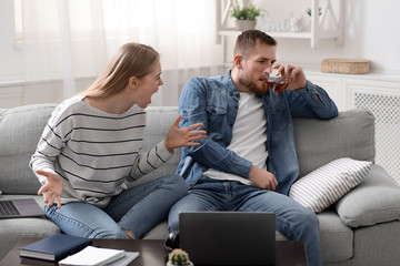 Desperate woman arguing with drunk husband at home
