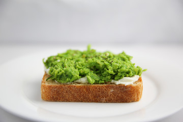 Classic English pea and ricotta toast on white plate