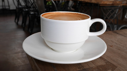 Hot coffee cappuccino latte on wooden background in coffee shop