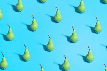 Minimal flat lay food texture. Summer abstract trendy fresh concept. green pear pattern on bright light blue background, copy space.