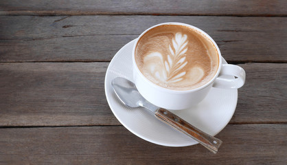 Hot coffee cappuccino latte art milk foam with spoon on wooden background