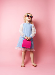 Little girl child in sunglasses with a pink redicle.