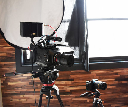 Professional camera setup with tripods & light reflector. We have a small 4k Mirrorless camera VS a big  4.6k digital movie camera. You  can use the window as a natural light source for your videos. 
