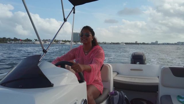 A female model driving a speed boat in Haulover bay Miami, Florida