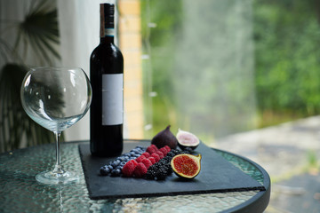 Berry wine, figs, blueberries, raspberries and blackberries on slate, berries, summer crop  
