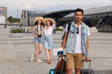The man is not happy that he is forced to carry luggage himself.