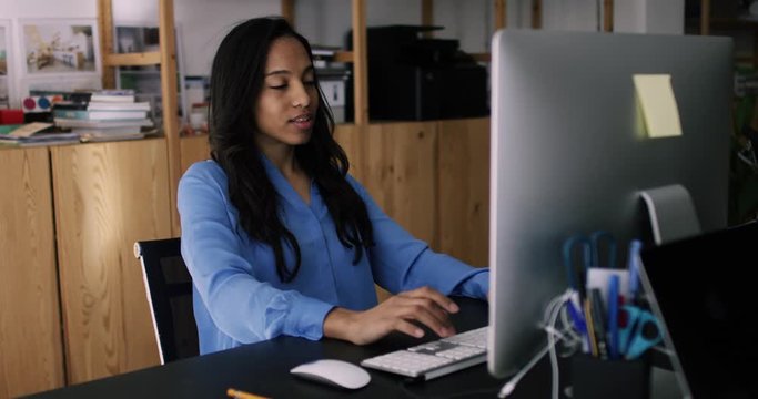 African American female employee working on PC computer with mouse at office desktop table. Dark skinned woman coworker sitting at her workplace. Online shopping and network request. 4K RED camera

