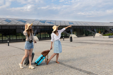 Tourists stand with suitcases at the train station.