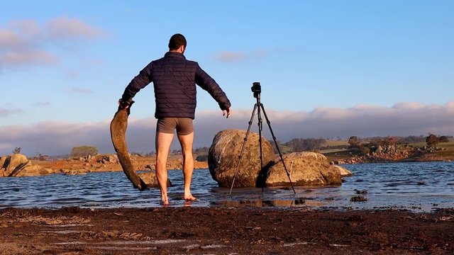 Time lapse of photographer setting up camera and tripod at waters edge