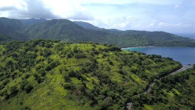 Drone footage of hills and cliffs by the ocean. The grass is growing on the mountain by the sea.