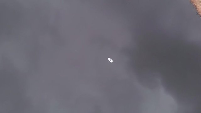 A person on a small fishing boat in the middle of a Swedish lake.