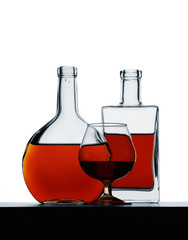 Bottle and glass with cognac on white background, isolated