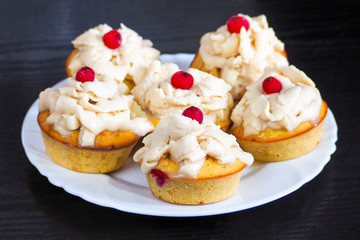 gluten-free muffins made from corn and rice flour with mascarpone cream and currant filling on a white plate on a dark background .pie for the holiday. gluten-free diet
