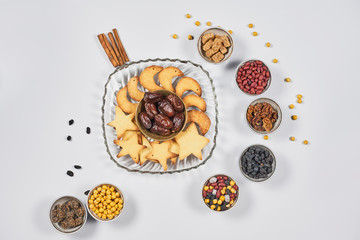 Iftar foods on white table. Traditional middle-eastern lunch with cookies and dry date fruits