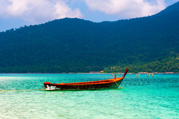 Fototapeta na wymiar Long tail boat on the sea at Ko Lipe island, Thailand. Tropical island with white sand, beach and turquoise sea is part of Tarutao National Marine Park. Idyllic vacation, relaxation in paradise.
