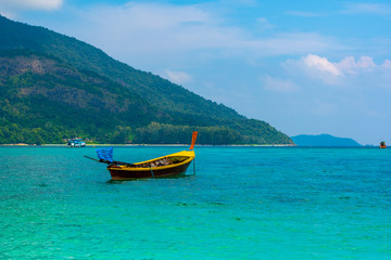 Naklejka na ściany i meble Long tail boat on the sea at Ko Lipe island, Thailand. Tropical island with white sand, beach and turquoise sea is part of Tarutao National Marine Park. Idyllic vacation, relaxation in paradise.