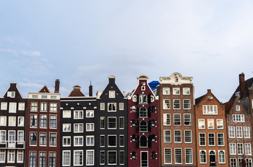Fototapeta premium Traditional Dutch architecture colorful houses at Damrak in Amsterdam, Netherlands