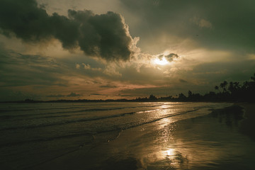 Świetlisty zachód słońca na tropikalnej plaży.